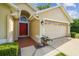 Exterior shot of the house featuring a red front door, landscaping, and an attached two-car garage at 1045 View Pointe Way, Lakeland, FL 33813