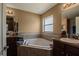 Bathroom featuring a soaking tub with decorative tile surround and a double sink vanity at 1619 Prairie Blossom Dr, Lakeland, FL 33810