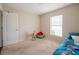 Comfortable bedroom featuring neutral carpet, a window and simple decor; bright and inviting space at 1619 Prairie Blossom Dr, Lakeland, FL 33810