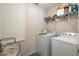 Efficient laundry room with a washer, a dryer, and shelving for organized storage at 1619 Prairie Blossom Dr, Lakeland, FL 33810