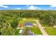 An aerial view of a cozy home with a well-maintained lawn, set against a backdrop of dense trees at 1896 12Th St, Orange City, FL 32763