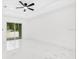 Empty bedroom with white floors and walls. Large window and ceiling fan at 1896 12Th St, Orange City, FL 32763