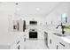 Well-lit kitchen showcasing a stainless steel appliance suite, white cabinets and stone countertops at 1896 12Th St, Orange City, FL 32763