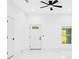Bright living room featuring sleek white walls, a ceiling fan, and a window at 1896 12Th St, Orange City, FL 32763