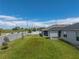 The backyard includes a covered patio, a lush green lawn, a privacy wall, and young trees at 1029 Mattie Pointe Way, Auburndale, FL 33823