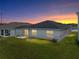 A home backyard and covered patio with green grass and view of sunset at 1029 Mattie Pointe Way, Auburndale, FL 33823