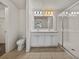 Bathroom featuring a double sink vanity, tiled floors, and a glass-enclosed shower at 1029 Mattie Pointe Way, Auburndale, FL 33823