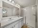 Bathroom featuring a large mirror above a double vanity and glass shower doors at 1029 Mattie Pointe Way, Auburndale, FL 33823
