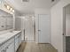 Bright bathroom featuring a double vanity, tiled floors, and a glass-enclosed tiled shower at 1029 Mattie Pointe Way, Auburndale, FL 33823