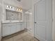 Bright bathroom with double sink vanity, tiled floor, and glass-enclosed shower at 1029 Mattie Pointe Way, Auburndale, FL 33823