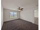 Carpeted bedroom featuring a ceiling fan, natural light from a window, and a neutral color palette at 1029 Mattie Pointe Way, Auburndale, FL 33823