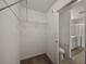 Walk-in closet featuring shelving, carpeted floors, and a view to the Primary bathroom at 1029 Mattie Pointe Way, Auburndale, FL 33823