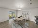 Bright dining area with modern chandelier, decor, and sliding glass doors to the backyard at 1029 Mattie Pointe Way, Auburndale, FL 33823
