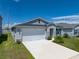 Beautiful one story home with manicured lawn and a two car garage on a sunny day at 1029 Mattie Pointe Way, Auburndale, FL 33823
