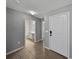Hallway with tile flooring leading to a white door and an open bathroom at 1029 Mattie Pointe Way, Auburndale, FL 33823