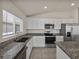 Close up of the kitchen with granite countertops, stainless steel appliances and bright white cabinetry at 1029 Mattie Pointe Way, Auburndale, FL 33823