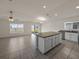 Spacious kitchen with an island and open floor plan with access to the living room with a ceiling fan at 1029 Mattie Pointe Way, Auburndale, FL 33823