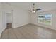 Open living room with ceiling fan and tile flooring, adjacent to the hallway and carpeted room at 1029 Mattie Pointe Way, Auburndale, FL 33823