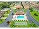 Aerial view of community pool, shuffleboard courts, and clubhouse surrounded by lush landscaping and parking at 480 Nighthawk Dr, Lakeland, FL 33813