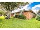 Charming brick home exterior with mature tree and landscaped yard at 480 Nighthawk Dr, Lakeland, FL 33813