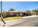 A well-maintained single-story brick home featuring an open carport, manicured lawn, and mature landscaping at 480 Nighthawk Dr, Lakeland, FL 33813