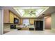 Bright kitchen with wooden cabinets, a modern black refrigerator, and a dropped ceiling with a ceiling fan at 480 Nighthawk Dr, Lakeland, FL 33813