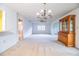 Spacious living room featuring a chandelier, built-in china cabinet, and neutral carpet flooring at 480 Nighthawk Dr, Lakeland, FL 33813