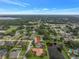 An aerial view of a home featuring a well-manicured lawn, mature trees, and a serene pond at 6414 Highlands In The Woods St, Lakeland, FL 33813