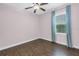 Bedroom with hardwood floors, ceiling fan, and a window with patterned curtains at 6414 Highlands In The Woods St, Lakeland, FL 33813