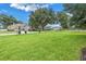 A wide shot of a grassy lot with mature trees and a black fence, ideal for outdoor activities at 6414 Highlands In The Woods St, Lakeland, FL 33813