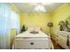 Charming bedroom with yellow walls, a white bed frame, and window coverings at 7525 Catherine Dr, Lakeland, FL 33810
