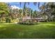 Lush front yard featuring well-maintained landscaping with tropical plants and brick home at 7525 Catherine Dr, Lakeland, FL 33810