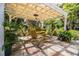 Relaxing patio with a pergola, yellow chairs, and lush landscaping at 7525 Catherine Dr, Lakeland, FL 33810