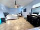 Light blue bedroom features a ceiling fan, tan tile flooring, and a large black dresser at 1109 Brenton Manor Dr, Winter Haven, FL 33881
