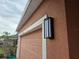 Exterior features a stucco wall and garage door with modern outdoor light fixture at 1109 Brenton Manor Dr, Winter Haven, FL 33881