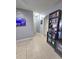 Hallway view with tile flooring, light grey paint and decorative book shelving at 1109 Brenton Manor Dr, Winter Haven, FL 33881
