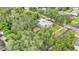 Aerial view of home featuring ample yard space, lush trees, and a shimmering blue pool at 1705 Davis Ave, Bartow, FL 33830