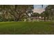 Expansive green backyard featuring a quaint home partially shaded by a large tree at 1705 Davis Ave, Bartow, FL 33830