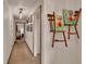 Hallway featuring chair art display and a glimpse into an adjacent bedroom with a bed at 1705 Davis Ave, Bartow, FL 33830