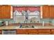 Well-lit kitchen featuring a double sink, window with curtains, and ample counter space at 1705 Davis Ave, Bartow, FL 33830
