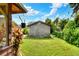 Backyard view features a shed, lush lawn, and tropical foliage at 1819 Meadowbrook Ave, Lakeland, FL 33803
