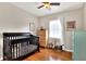 Well-lit Bedroom with hardwood floors, crib, dresser, and vintage accents at 1819 Meadowbrook Ave, Lakeland, FL 33803
