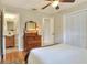 Bright bedroom with hardwood floors, connecting bathroom, closet, and vintage dresser at 1819 Meadowbrook Ave, Lakeland, FL 33803