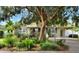 Inviting home with a lush front yard, large tree, carport and freshly painted exterior at 1819 Meadowbrook Ave, Lakeland, FL 33803