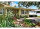 Home showcasing a cozy front porch with a seating area, beautiful plants, and a well-maintained lawn at 1819 Meadowbrook Ave, Lakeland, FL 33803