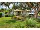 Charming single story home featuring mature landscaping, a manicured lawn, and a welcoming front porch at 1819 Meadowbrook Ave, Lakeland, FL 33803