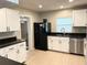 Bright kitchen features white cabinets, stainless steel appliances, and black countertops at 1819 Meadowbrook Ave, Lakeland, FL 33803