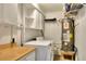 Functional laundry area with washer, dryer, water heater, storage cabinets, and butcher block folding table at 1819 Meadowbrook Ave, Lakeland, FL 33803