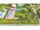 Aerial view of a spacious backyard with a swimming pool, fire pit, sheds, and lush greenery at 4390 Sunnyside Dr, Lakeland, FL 33810