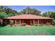 Charming brick home featuring a red door and manicured landscaping at 4428 Sugartree E Dr, Lakeland, FL 33813